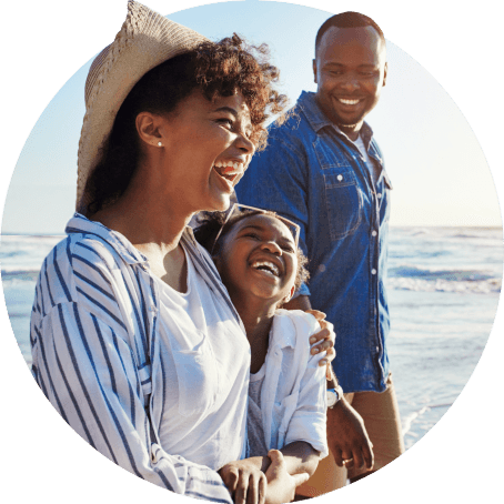 Happy family of three enjoying beach vacation, demonstrating wellness benefits of comprehensive family health insurance plans