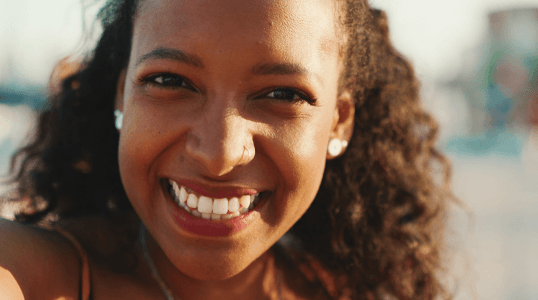 Young woman with bright smile showcasing healthy teeth from affordable dental insurance covering cleanings, X-rays, and fillings